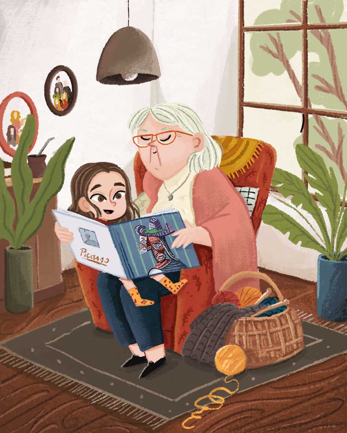 An illustration of an older woman with glasses sitting in an armchair, reading an open book titled 'Picasso' with a colorful drawing, to a smiling child sitting on her lap. A basket of yarn and knitting needles is beside the chair.